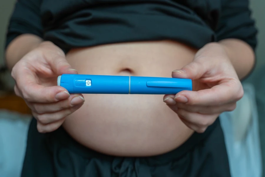 Woman holding GLP-1 medication injection pen.